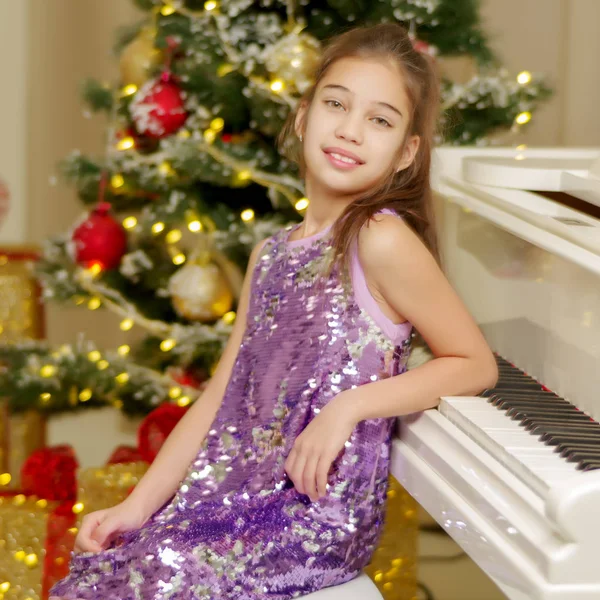 Kleines Mädchen in der Nähe von Klavier und Weihnachtsbaum. — Stockfoto