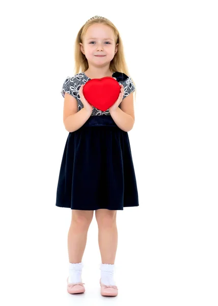 Uma menina está segurando um coração . — Fotografia de Stock