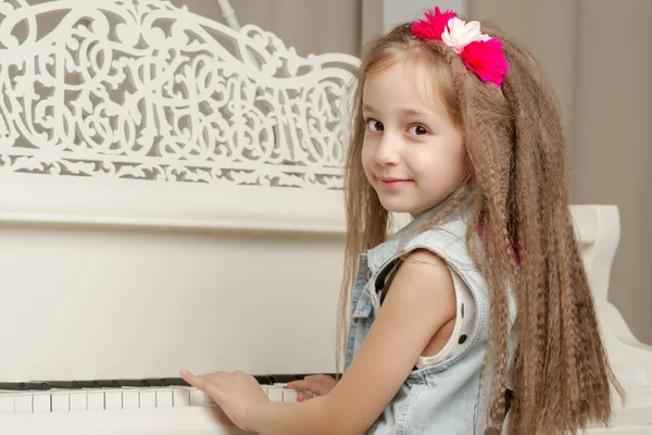 La ragazza è al pianoforte a coda bianco. — Foto Stock