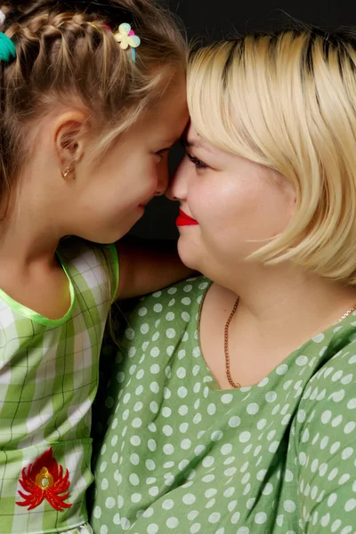Mom and daughter are hugging on a black background. — Stock Photo, Image