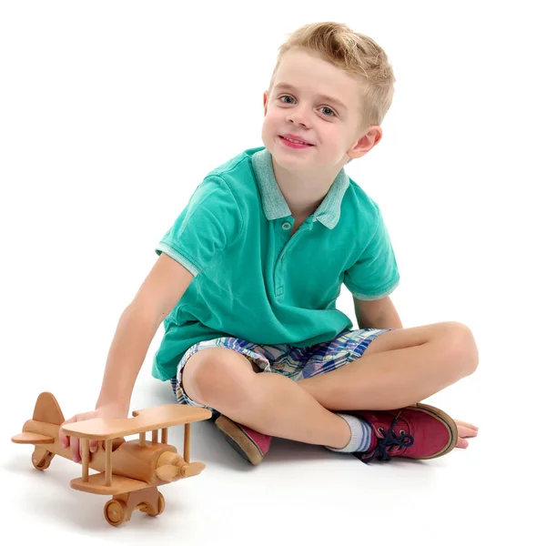 Petit garçon jouant avec un avion en bois — Photo