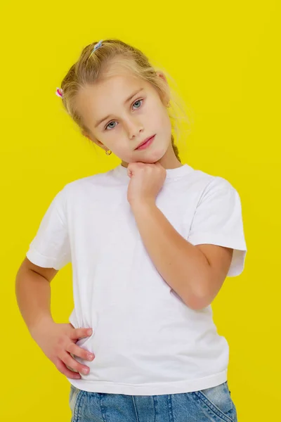 Känslomässig liten flicka i en ren vit T-shirt. — Stockfoto