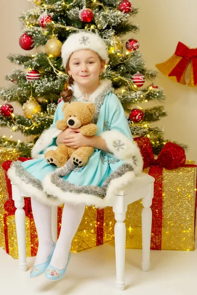 Liten flicka i snö maiden kostym med en nallebjörn nära th — Stockfoto