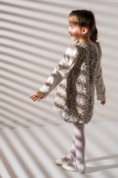 Portret van een klein meisje in de stralen van licht. — Stockfoto