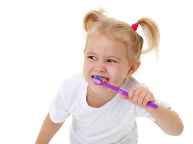 Küçük bir kız dişlerini fırçalıyor..
