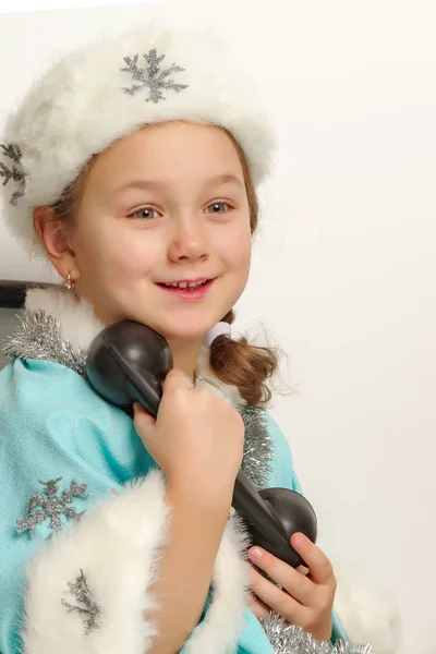 Mała dziewczynka w stroju dziewiczy śnieg rozmawia na stary pho — Zdjęcie stockowe