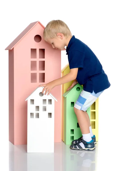 Маленький хлопчик грає з різнокольоровими будинками . — стокове фото
