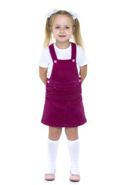 Stüdyoda beyaz arka planda poz veren küçük kız..