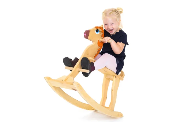 Chica balanceándose en un caballo de madera . —  Fotos de Stock