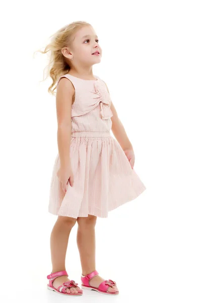 Niña en un vestido que se desarrolla en el viento . — Foto de Stock