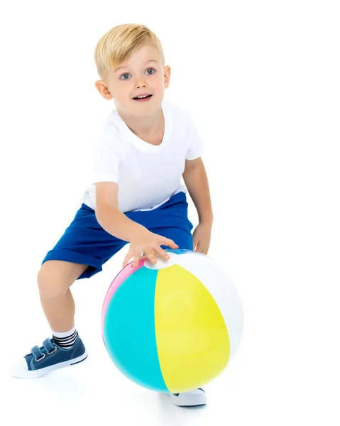 Um menino está brincando com uma bola . — Fotografia de Stock