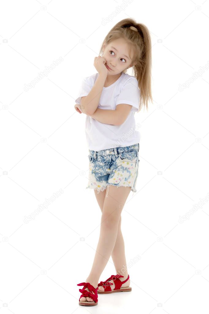 Beautiful little girl in short shorts and a pure white T-shirt on which you can make any inscription. The concept of advertising, including childrens products. In full growth. Isolated on white