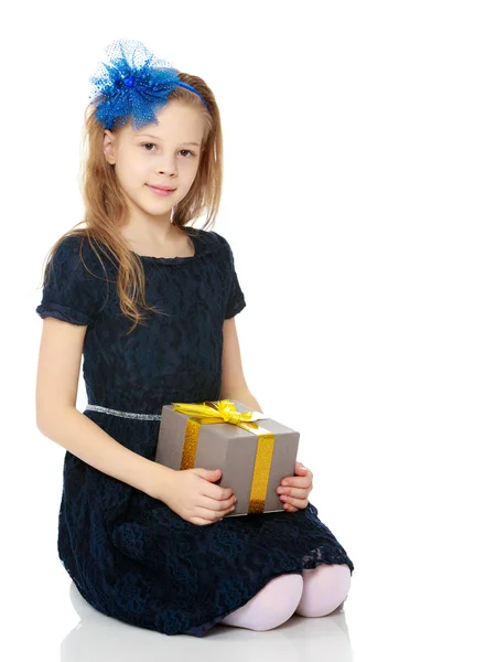 Schattig klein meisje met een gift in de hand. — Stockfoto