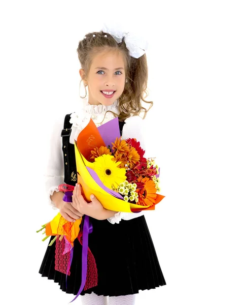 Petite fille va à l'école avec un bouquet de fleurs. — Photo