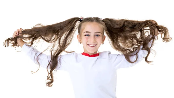 Een klein meisje repareert haar haar. — Stockfoto