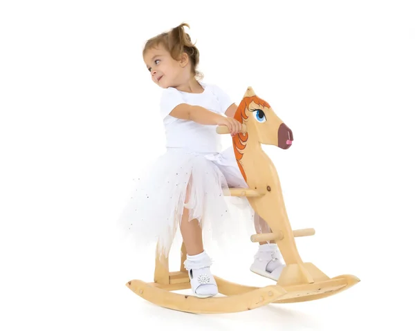 Menina balançando em um cavalo de madeira . — Fotografia de Stock