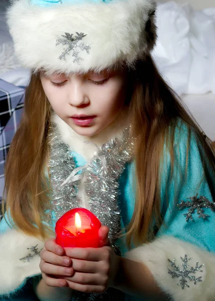 Menina em um traje de Ano Novo com uma vela. — Fotografia de Stock