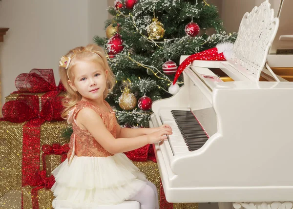 Menina perto do piano e árvore de Natal . — Fotografia de Stock