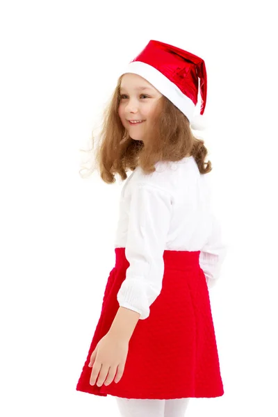 A little girl with a gift in a Santa Claus hat. — Stock Photo, Image