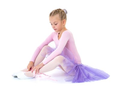 Küçük kız bale ayakkabı giymiyor.