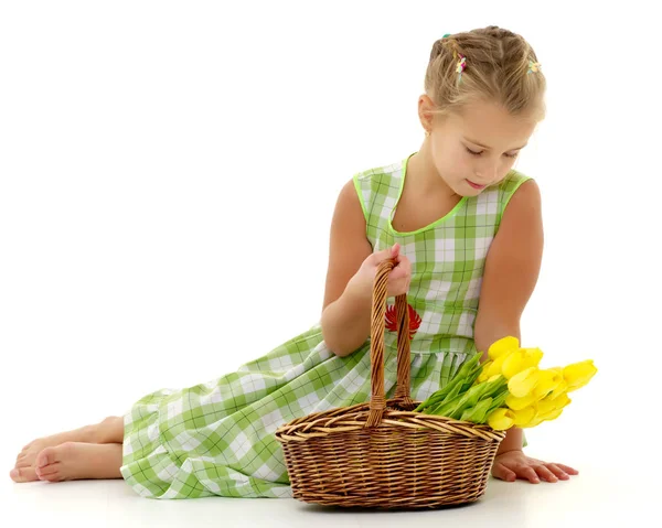 Cute little girl with a basket of flowers. — Stock Photo, Image