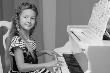 Küçük kız piyano, siyah ve beyaz fotoğraf çalış.