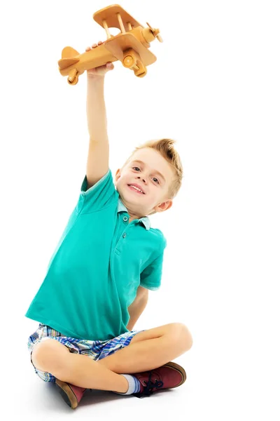 Kleine jongen spelen met houten vliegtuig — Stockfoto