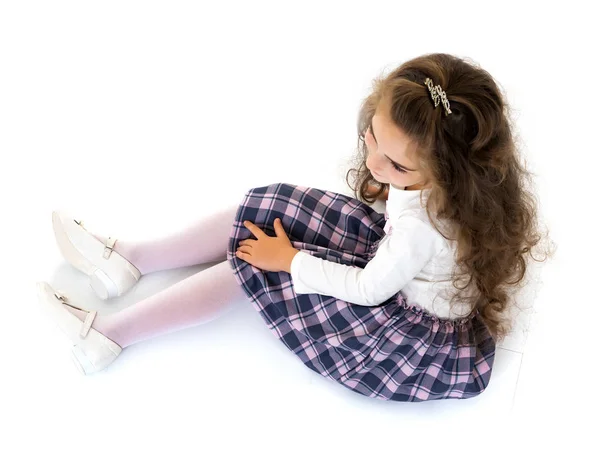 Kleines Mädchen sitzt auf dem Boden. — Stockfoto