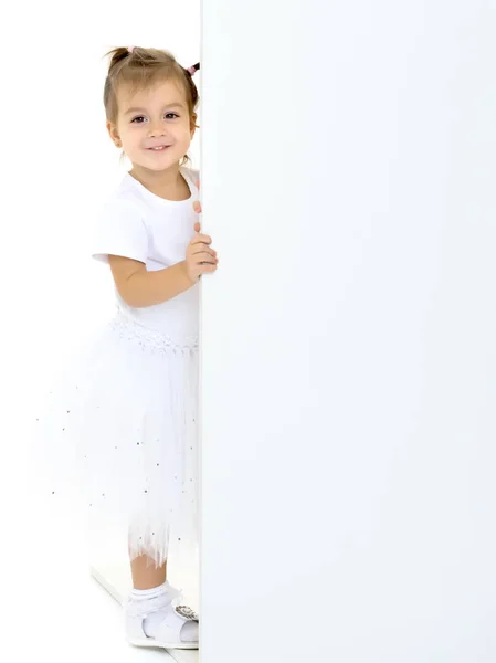 Uma menina está olhando por trás de uma bandeira vazia. — Fotografia de Stock