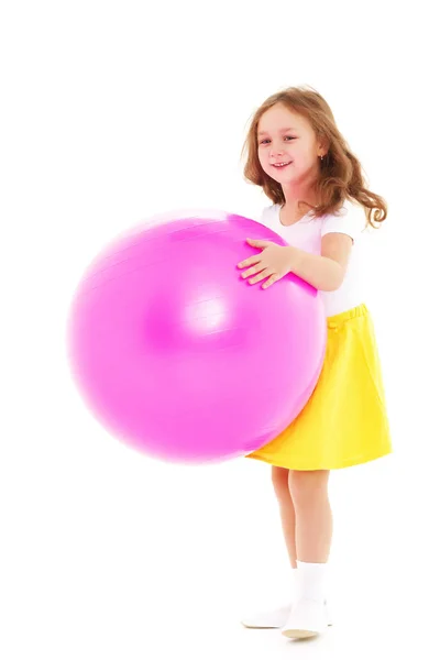 Bambina che fa esercizi su una palla grande per idoneità. — Foto Stock