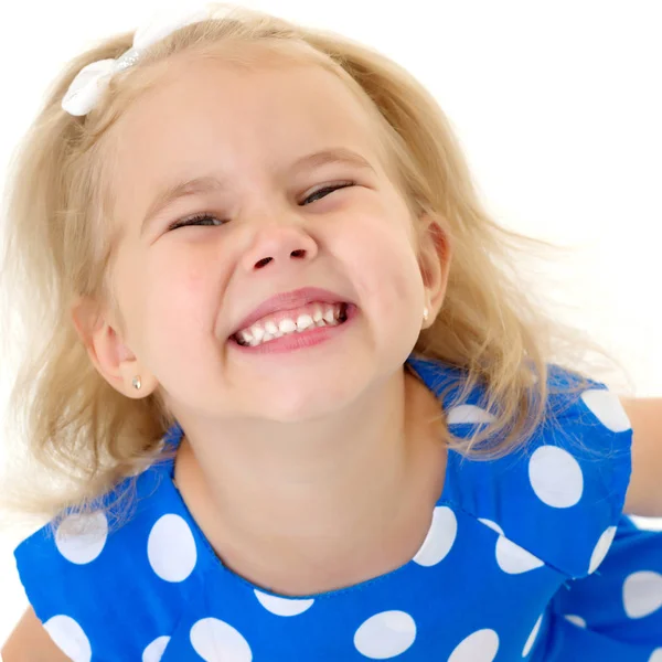 Een klein meisje pronkt met haar schone, zelfs tanden. — Stockfoto