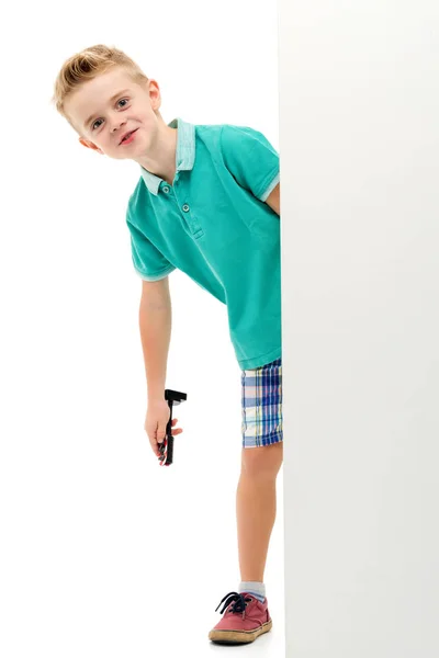 A little boy is looking from behind an empty banner. — Stock Photo, Image