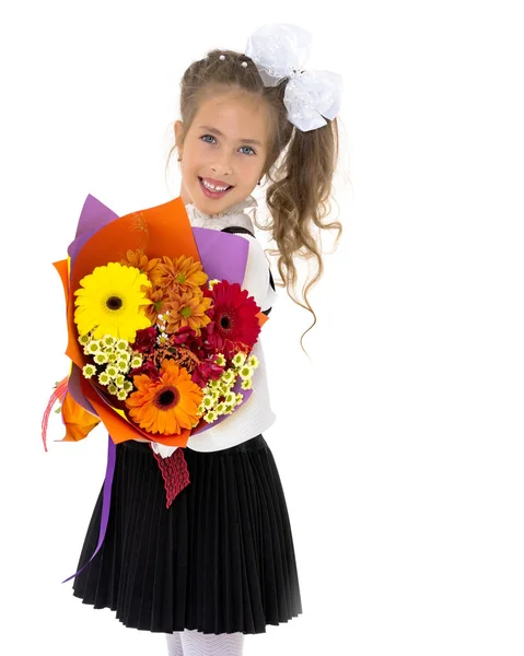 Meisje gaat naar school met een boeket bloemen. — Stockfoto