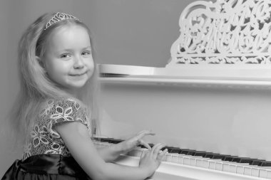 Küçük kız piyano, siyah ve beyaz fotoğraf çalış.
