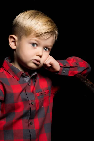 Kleine jongen op een zwarte achtergrond. — Stockfoto