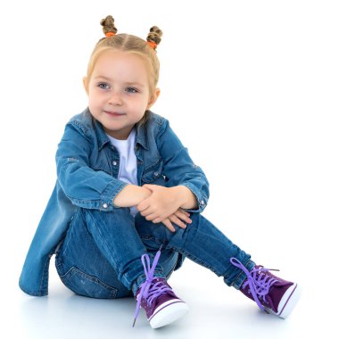 Küçük kız yerde oturuyor..