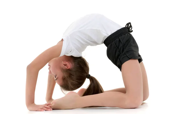 The little gymnast performs a bridge. — Stock Photo, Image