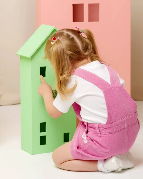 Meisje speelt met houten huizen. — Stockfoto