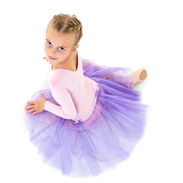 Liten flicka ballerina i bilden poserar på golvet. — Stockfoto