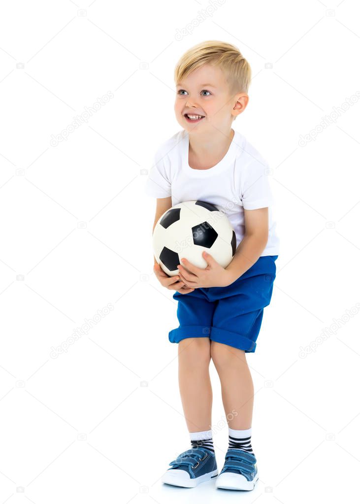 A sporty little boy is playing with a soccer ball. Concept of a healthy lifestyle, sport and fitness. Isolated on white background.