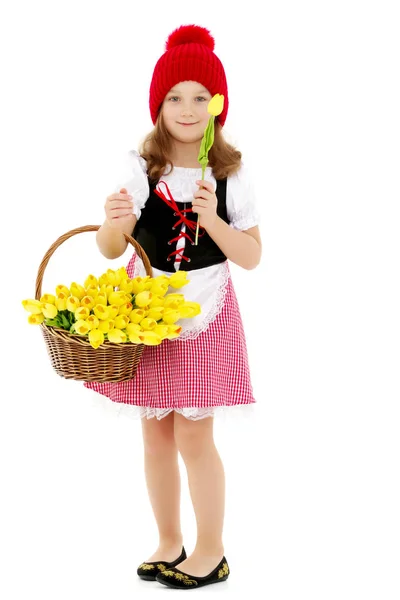 Niedliches kleines Mädchen mit einem Korb voller Blumen. — Stockfoto