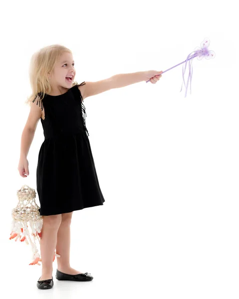 Ein kleines Mädchen mit einem Zauberstab. — Stockfoto