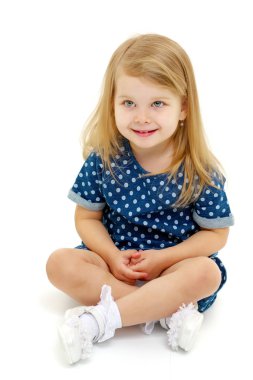 Küçük kız yerde oturuyor..