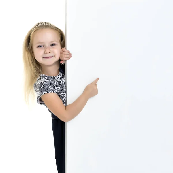Маленькая девочка указывает пальцем на белый баннер . — стоковое фото