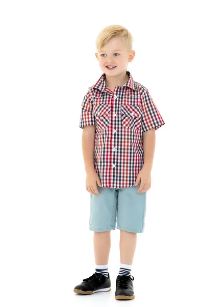 En söt liten pojke i en skjorta och shorts. — Stockfoto