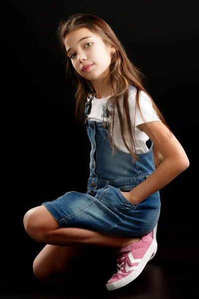 Bambina vestita in denim su sfondo nero . — Foto Stock