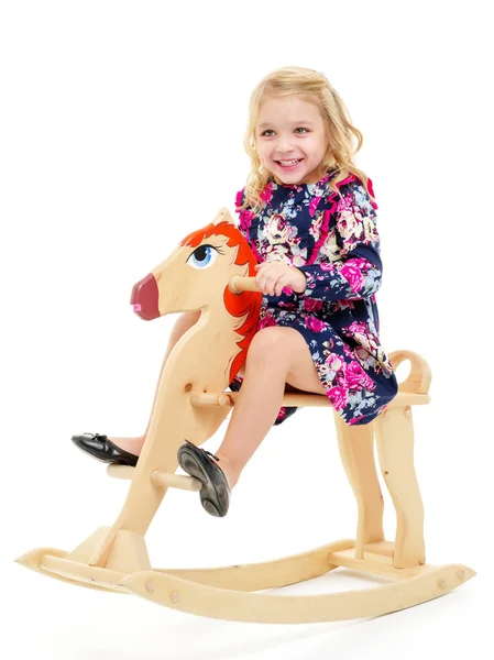 Ragazza che oscilla su un cavallo di legno . — Foto Stock