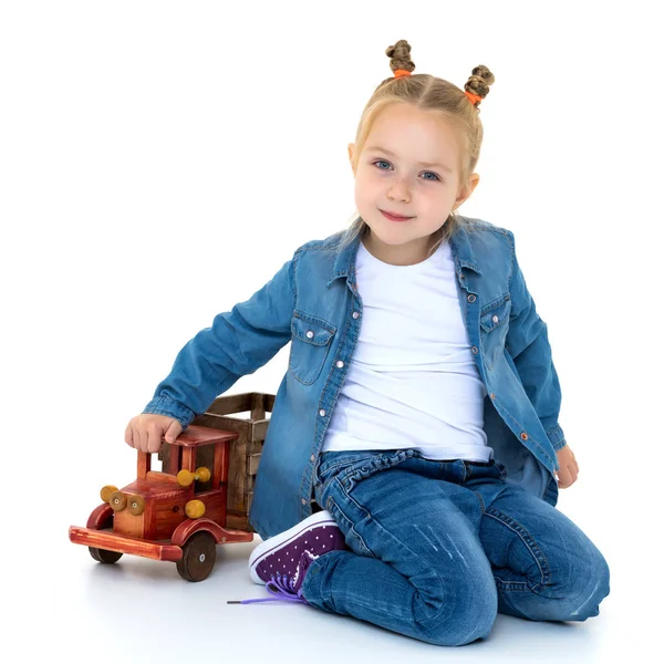 小さな女の子は、木造車で遊んでください。. — ストック写真