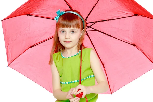 Das Mädchen geschlossen vor Sonne und Regen unter einem roten Regenschirm. — Stockfoto