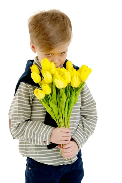 Mały chłopiec z bukietem kwiatów tulipany. — Zdjęcie stockowe